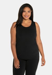 Zwarte mouwloze top gemaakt van zachte stof, met een ronde halslijn en een relaxed fit. Gecombineerd met zwarte onderkleding.