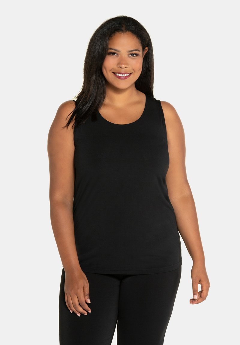 Zwarte mouwloze top gemaakt van zachte stof, met een ronde halslijn en een relaxed fit. Gecombineerd met zwarte onderkleding.