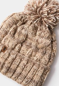 Dzianinowa czapka typu beanie w różnych odcieniach brązu i kremu z teksturowanym wzorem warkocza, wykończona puszystym pomponem na szczycie i metką z logo.