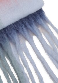 Wollen sjaal in verloopkleuren van lichtblauw naar donkerblauw, met lange, franjes aan de randen en een zachte, gestructureerde oppervlakte.