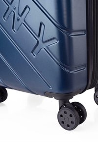 Maleta de carcasa dura en azul oscuro con una superficie texturizada, que cuenta con un logo prominente y cuatro ruedas negras para facilitar la movilidad.