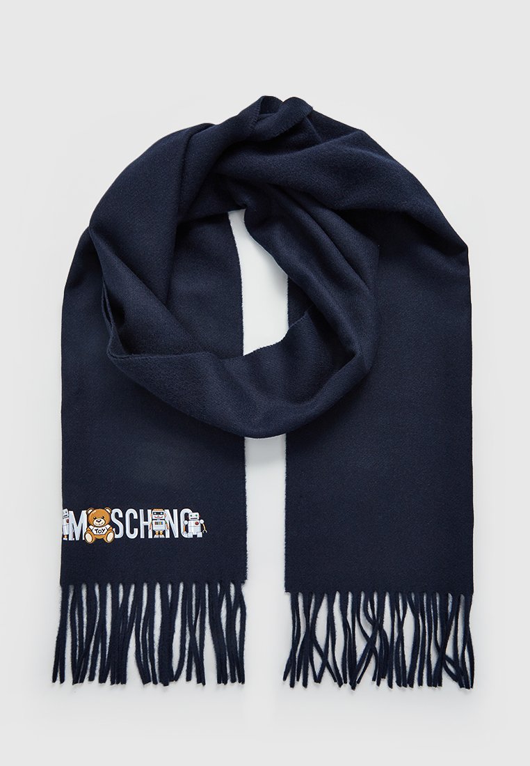 Sciarpa di lana blu scuro con estremità frangiate e nome del marchio Moschino ricamato, con un robot giocattolo e un orsetto su un lato.