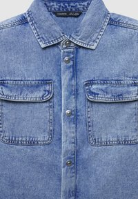 Jasnoniebieska koszula z denimu z klasycznym kołnierzykiem, wyposażona w dwie zapinane na guziki kieszenie na piersi oraz srebrne napy z przodu.