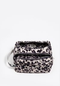 Bolso de tela con estampado de leopardo con dos compartimentos con cremallera, patrón negro sobre beige, y una correa blanca con texto en negro.