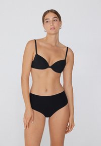 Zwart lingerieset met een gladde, gewatteerde beha met dunne bandjes en hoge taille slips, beiden in een simpel, naadloos ontwerp.