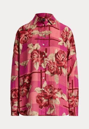 Button-up shirt in pink with a floral pattern featuring roses, textured fabric, and long sleeves. Collared with a slightly loose fit.