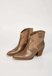 Bottines métalliques brunes avec orteils pointus, fermetures éclair latérales, coutures décoratives et talons blocs texturés. Matériaux lisses et semblables à du daim.