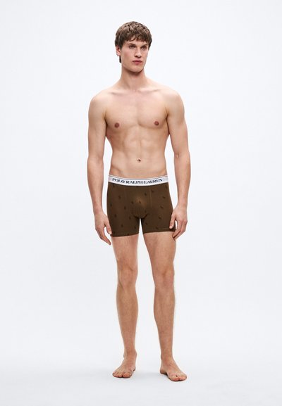 Brown boxer shorts made of stretchy fabric, featuring a white waistband with "POLO RALPH LAUREN" logo and small black polo player patterns.