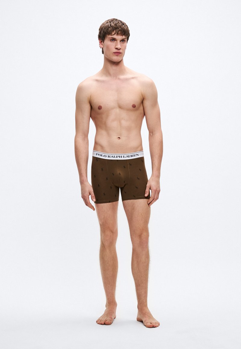 Hnedé boxerky z pružnej tkaniny s bielym pásom v páse s logom "POLO RALPH LAUREN" a malými čiernymi vzormi hráčov póla.