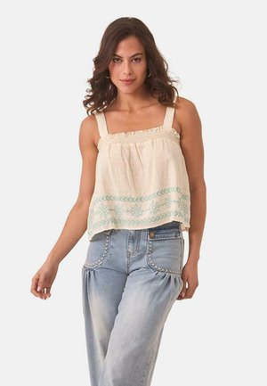Top de lino color crema con tirantes ajustables, cuerpo smock, bordado floral azul en el dobladillo y corte holgado.