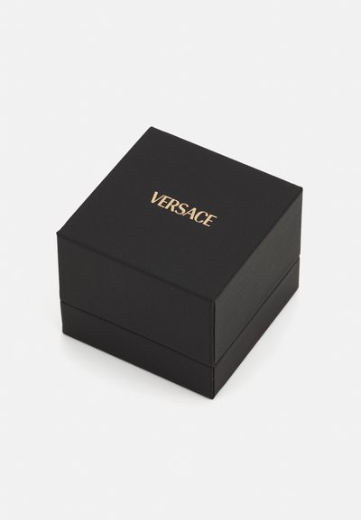 Čierna darčeková krabička s textúrovaným povrchom. Zlaté logo "VERSACE" potlačené na vrchu. Štvorcový tvar, navrhnutá na šperky alebo doplnky.