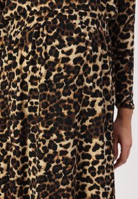 Jurk met luipaardprint in een mix van beige, bruin en zwart, met een zachte textuur en een elastische tailleband voor een aansluitende pasvorm.