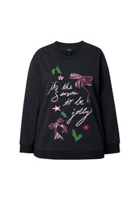 Sudadera negra con gráficos festivos: lazos rosas, hojas verdes y estrellas con el texto "es la temporada de ser alegre" en blanco.
