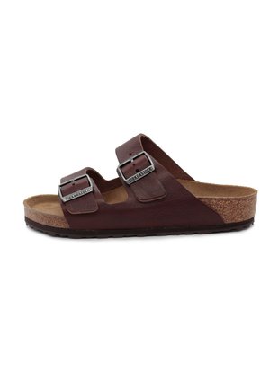 Brune lædersandal med to justerbare spænder, korkfodseng og struktureret sål. Har et semi-åbent design og rund tå.