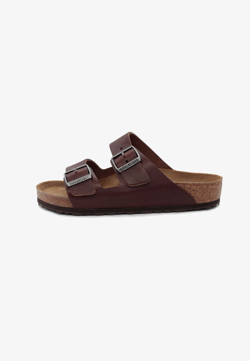 Sandale en cuir marron avec deux boucles réglables, semelle en liège et semelle texturée. Présente un design semi-ouvert et un bout arrondi.