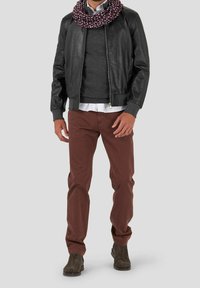 Veste bomber en cuir noir, pull gris, chemise blanche, pantalon bordeaux, écharpe à motifs, bottes chevilles marron foncé. Textures lisses et design ajusté.
