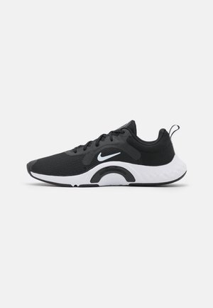 Zapatilla de running Nike en blanco y negro con parte superior de malla, cierre de cordones, suela acolchada y logo Nike swoosh en el lateral.