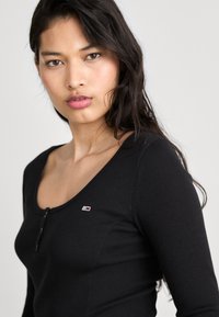 Tommy Jeans HENLEY FLARE DRESS - Φόρεμα από ζέρσεϊ - black