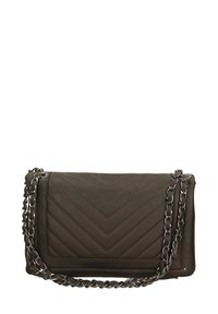 Borsa a tracolla trapuntata verde scuro con motivo a zig zag, dotata di una tracolla in catena argentata e una texture in pelle liscia. Forma rettangolare compatta.