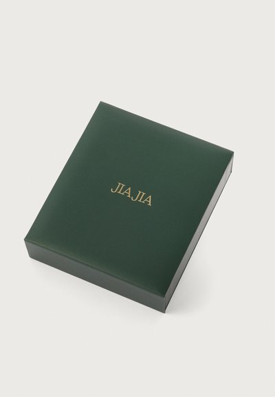 Zelena papirnata kutija s glatkom teksturom, s zlatno foliranim natpisom "JLA JIA" na vrhu, kvadratnog oblika, bez vidljivog mehanizma za zatvaranje.