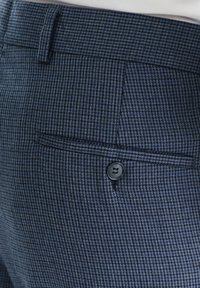 Granatowe spodnie w wzory wykonane z tkaniny tkanej, z płaskim przodem, boczną kieszenią i czarnym zapięciem na guzik w pasie.