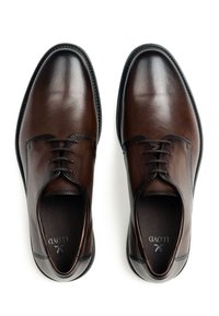 Zapatos de vestir de cuero marrón con un acabado pulido, punta redondeada y diseño de cordones. Presentan costuras en contraste y una textura suave.