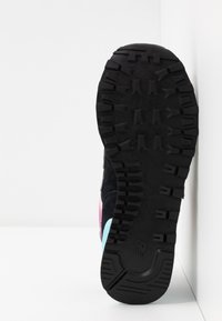 Semelle de chaussure en caoutchouc noir avec des motifs de crampons prononcés. Présente des accents colorés en rose et bleu clair sur les côtés. Surface texturée.