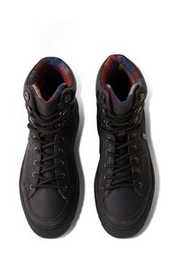 Czarne wysokie buty sportowe z teksturowaną skórzaną cholewką, kontrastowym kolorowym materiałem wyściełającym i metalowymi oczkami na sznurowadła. Gruba gumowa podeszwa.
