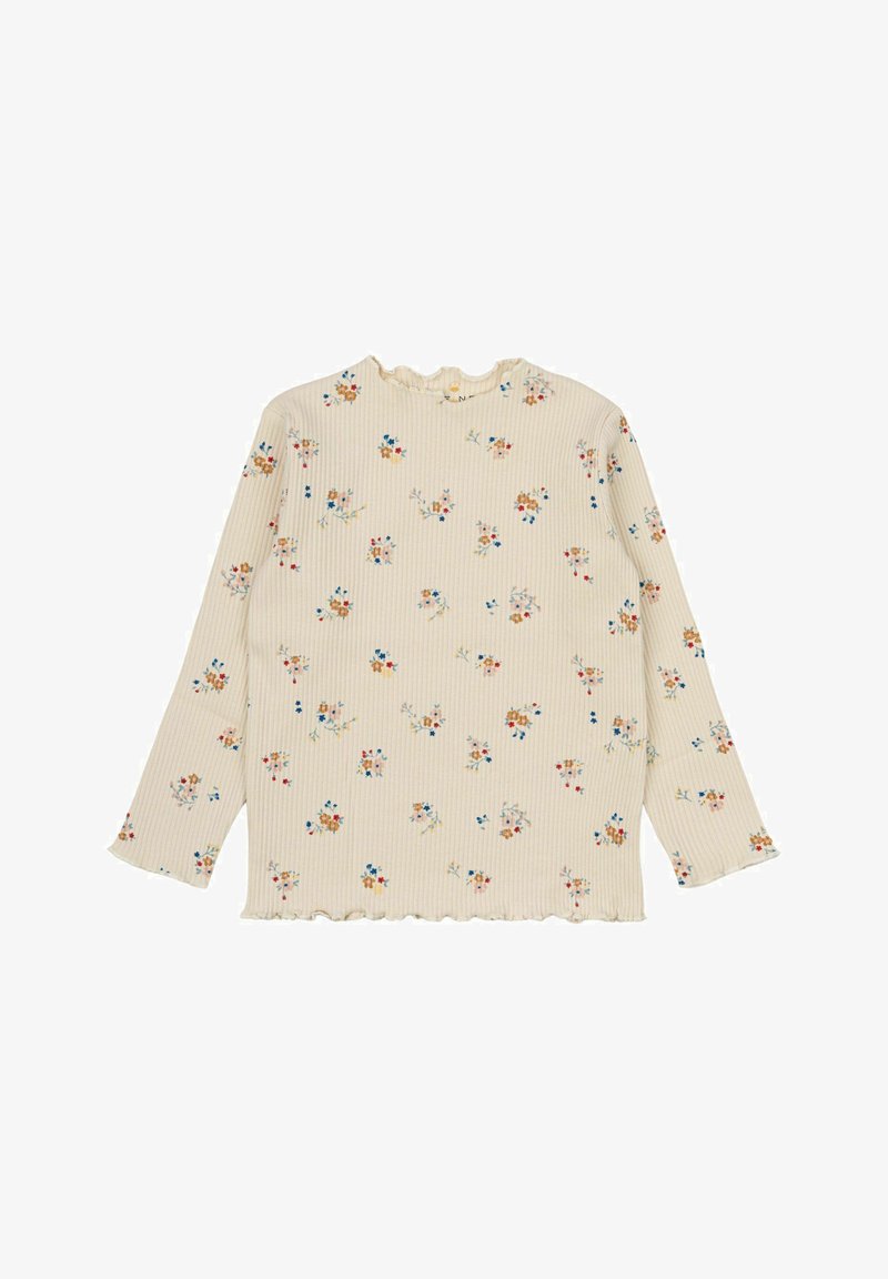 Top lungo a maniche con texture a coste color crema, caratterizzato da motivi floreali in blu, arancione e rosso. Dettagli scallop sul collo e sull'orlo.