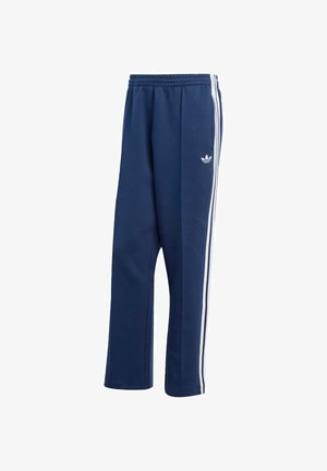 Marina sportbyxor i mjukt material, med vita sidostreck och en liten vit logga på vänster höft. Elastisk midja synlig.