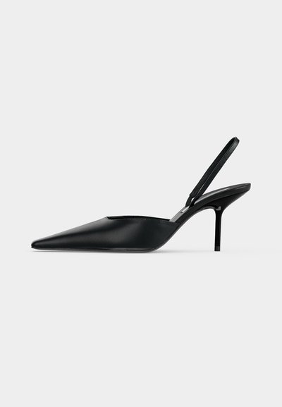 Escarpin slingback en cuir noir à bout pointu avec un talon haut et fin, présenté sur un fond gris clair.