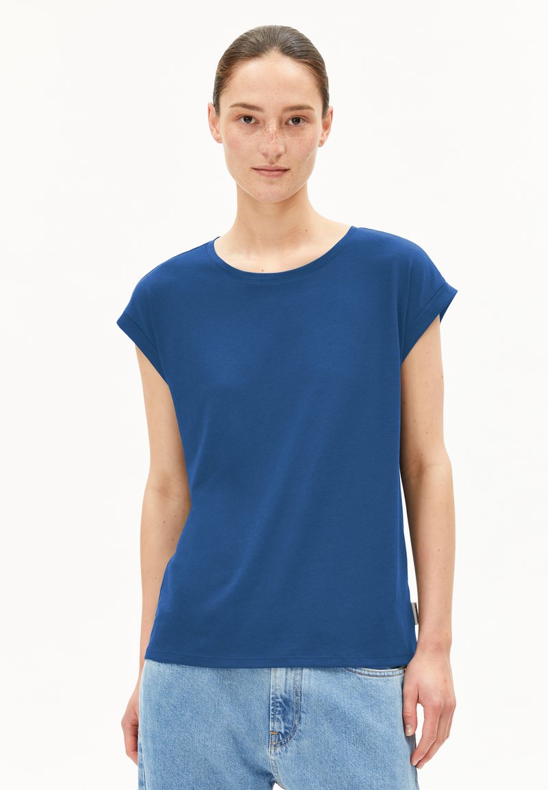 T-shirt bleu à manches courtes en coton doux, avec un col rond et une coupe décontractée, associé à un jean en denim bleu clair.