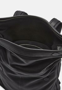 Borsa tote in pelle nera con un ampio interno, texture liscia, tasca con zip e chiusure a scatto. Design minimalista senza motivi visibili.