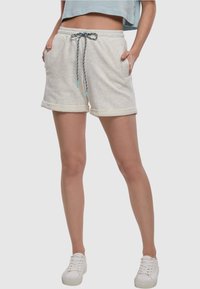 Lys grå fleece shorts med rullet kant, elastisk midje og flerfarget snor. Har sidelommer og en avslappet passform.