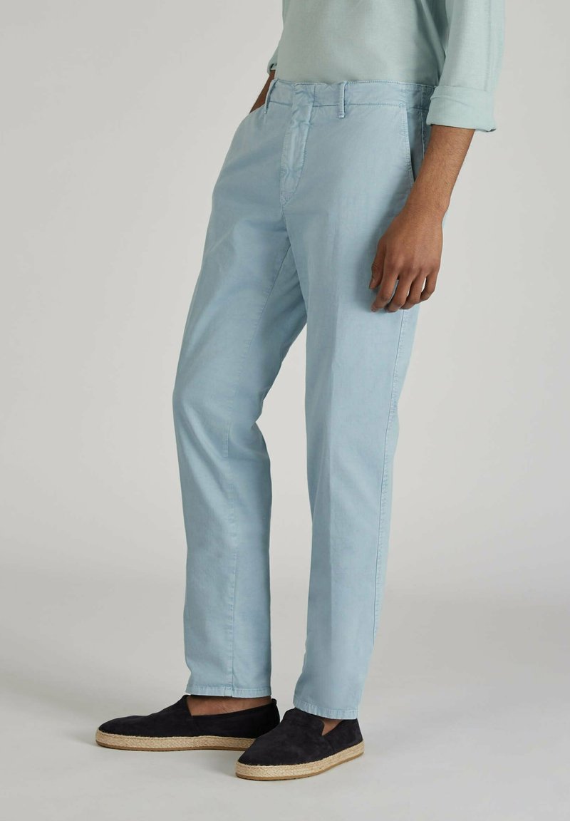 Chinos in cotone blu chiaro con una vestibilità slim, dotati di fronte piatto, passanti per cintura e tasche laterali. Abbinati a scarpe slip-on in suede nero.