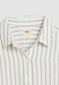 Chemise boutonnée blanche avec des rayures verticales grises, col classique et un petit logo Levi's. Le tissu semble léger et texturé.