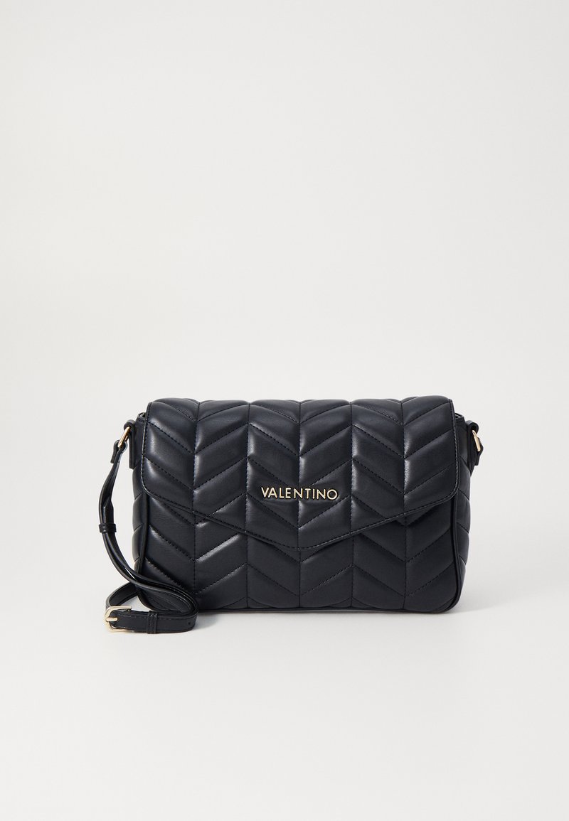 Black leather crossbody bag featuring a quilted chevron design, magnetic flap closure, and gold logo accent on the front.