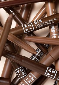 Automatiska ögonbrynspennor i olika nyanser av brunt, med tydlig märkning, matt finish och en vridbar design för enkel användning.