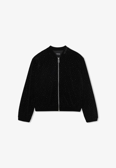 Zwarte fluwelen jas met ritssluiting, kleine glanzende studs, ribbelboorden en -zoom, en "VOLTAIRE" geborduurd op de kraag.