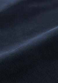 Getextureerde donkerblauwe stof met een fijn geweven patroon. Het oppervlak lijkt glad met een lichte glans, geschikt voor verschillende toepassingen.