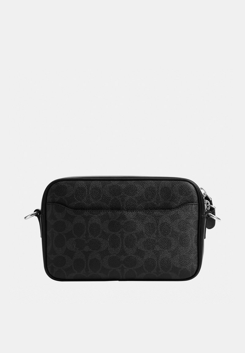 Bolso bandolera negro rectangular con un discreto patrón circular y herrajes metálicos plateados sobre un fondo liso.