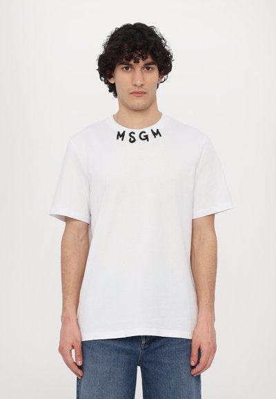 T-shirt en coton blanc à manches courtes, avec le lettrage noir "MSGM" sur le col. Design classique à col ras du cou.