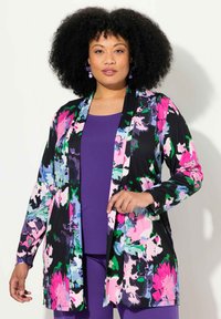Cardigan con estampado floral que presenta acentos en rosa brillante, verde y azul sobre un fondo negro. Tela suave, diseño de frente abierto, mangas largas.