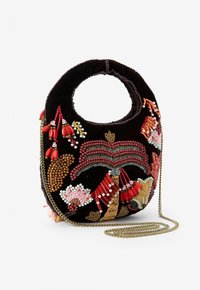 Sac en velours noir avec une poignée circulaire, comportant un délicat travail de perles en motifs floraux rouges, roses et beiges, ainsi qu'une bandoulière en chaîne dorée.