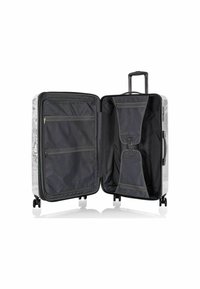 Valigia rigida bianca con design a mappa, caratterizzata da un ampio interno nero, numerose tasche con zip e un manico retrattile con ruote.