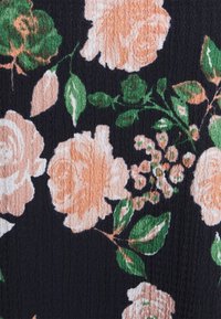 Blommig tyg med stora persikoroser och gröna blad på en strukturerad svart bakgrund. Designen inkluderar mindre rosa knoppar bland löven.