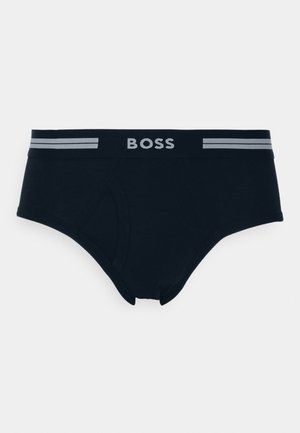 Schwarze Boxershorts mit einem weichen, elastischen Bund, auf dem das Wort "BOSS" in Grau steht, akzentuiert durch zwei graue Streifen. Glatte Textur, klassisches Design.
