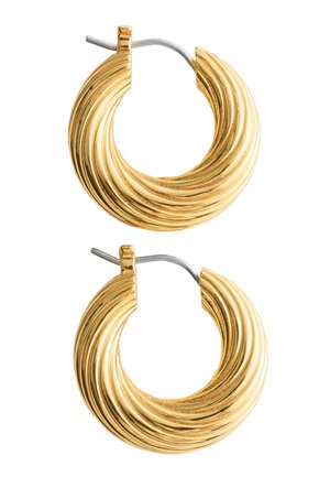 Paire de boucles d'oreilles créoles en ton or à rainures avec des clous en argent sur un fond blanc.