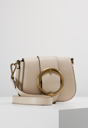 Béžová kožená taška přes rameno s texturovaným povrchem, s kulatým zlatým kováním a kontrastními detaily na popruhu.
