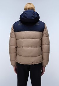 Giacca puffer con corpo beige e parte superiore blu navy, dotata di un colletto alto, design a righe e polsini elastici.